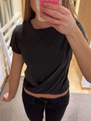 Svart croppad t-shirt - Snygg svart croppad t-shirt med korta ärmar och rund hals. T-shirten har en enkel och stilren design som passar perfekt till jeans eller kjol. Materialet känns mjukt och bekvämt, troligtvis bomull eller en bomullsblandning. Barnstorlek men skulle säga att den passar xxs/xs.