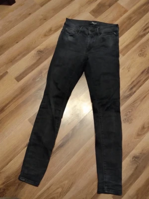 Svarta skinny jeans från replay - Säljer ett par svarta skinny jeans från Replay med klassisk normal midja. Jeansen har en smal passform och är tillverkade i stretchigt denimtyg för extra komfort. Perfekta för en trendig och avslappnad stil.