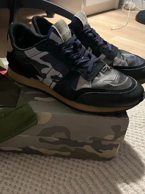 Valentino rockrunners med box, dustbag och äkthetskort! - Riktigt snygga Valentino rockrunners med original box, dustbag samt två små äkthetskort, som visar att skorna är äkta! Sjukt sköna att gå i då sulan är tillverkad för att vara så skön som möjligt! Nypris på dessa är över 8000 vilket betyder att mitt pris är väldigt bra! Men priset är trots det förhandlingsbart vid snabb affär!       Lite sliten innuti ena hälen men det är så lite så att man inte ens känner av det!                          Byten kan vara intressant!