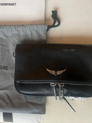 Zadig & Voltaire väska rock nano - Säljer min fina zadig väska då jag knappt använder den! Den är köpt av mig på NK Göteborg och mycket sparsamt använd. Inga tecken på slitage på läder, dragkedjor, axelrem eller insida. Flera fack och dragkedjor, avtagbar axelrem med både kort och lång kedja. Både originalkvitto och dustbag medföljer, skickar gärna fler bilder privat 🩷