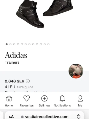 Svarta Adidas sneakers med nitar - Snygga svarta Adidas sneakers i high-top modell med blanka detaljer och silverfärgade nitar längs sidor och häl. Skorna har klassiska tre ränder på sidan och snörning framtill. Materialmix av läder och textil ger en cool och edgy look.