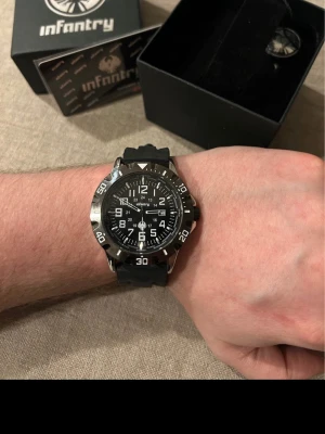 Infantry Diver 48mm Herrklocka - Säljer en mäktig dykarklocka från ovanliga Infantry. Klockan är i absolut nyskick, inga repor, plasten kvar på baksidan. Fungerar bra, originalarmband i gummi som passar alla, dykarring som roterar, datumvisare, vattentät osv. Behöver bara nytt batteri. Äkthet garanteras via deras kundtjänst men fås även med originalförpackning och certifikat.   Nypris: < 4700 SEK Mitt pris: 1289 SEK  Skickas alltid snabbt och spårbart (ofta samma dag) eller hämtas i Glumslöv.  Hör av dig vid frågor och se gärna