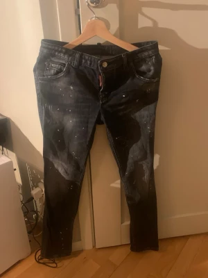 Svarta Dsquared2 jeans med stänk - Säljer ett par svarta jeans från Dsquared2 med coola vita färgstänk och slitningar. Ny pris ör runt 4 tusen men de är Bara och skriva om ni har frågor 