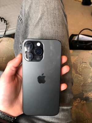 iPhone 14 Pro max svart - Snygg iPhone 14 Pro max  i svart med stilren design och mattsvart baksida i glas. Telefonen har tre stora kameror på baksidan och Apples klassiska logga. Ramen är i metall och skärmen är heltäckande utan hemknapp. Framkamera fungerar ejj