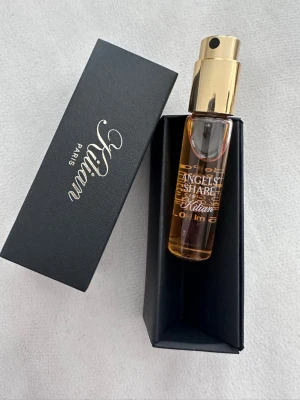 Kilian Angels' Share parfym 10 ml - Exklusiv parfym från Kilian, Angels' Share, i en elegant cylinderformad glasflaska med guldfärgad spraykork. Flaskan rymmer 10 ml och kommer i en stilren svart ask med Kilian-logga. Doften är lyxig och passar dig som gillar unika parfymer.