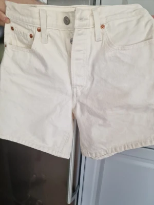 Vita Levi's shorts. - Snygga vita shorts från Levi's i klassisk modell. De är högmidjade. Använd en gång bara. Storlek W27.