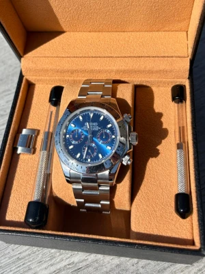 Seiko Mod Daytona Blue - Seiko Mod Daytona Blue i nyskick. Sportig och stilren modell med blå tavla som verkligen sticker ut på rätt sätt. Väldigt snygg både till vardag och finare tillfällen.  • Kronograf   • Safirglas   • Rostfritt stål   • Quartz movement   • Väldigt fint skick    Klockan fungerar perfekt och är i sjukt bra skick😊 less