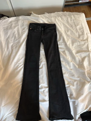 Svarta bootcut jeans från Cheap Monday - Säljer ett par svarta bootcut jeans från Cheap Monday med klassisk femficksdesign och lila logga bak. Jeansen har låg midja och utsvängda ben, Dom har en liten fläck på högra låret men inget som man lägger märke till💛Dom är i storlek 26/32. Skriv om ni har några frågor😊Dom är aldrig använda av mig men bara några få gånger från säljaren innan då dom tyvärr var förkorta på mig. Innerbens längden är 83cm och Midjemåttet är 32 cm