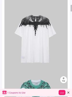 Vit t-shirt med svart vingmönster - Cool vit t-shirt med ett svart vinginspirerat mönster över axlarna och halsen. Oversized passform och korta ärmar, perfekt för en trendig streetstyle-look.