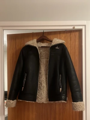 Svart läderjacka med teddy insida - Mysig jacka av äkta läder, väldigt varm på insidan, går att knäppa och är väldigt modern. Passar dig som letar efter en lite unik jacka som är perfekt  till höst/vintersäsong. Jackan är sprillans ny och är använd endast 3-4 gånger. 
