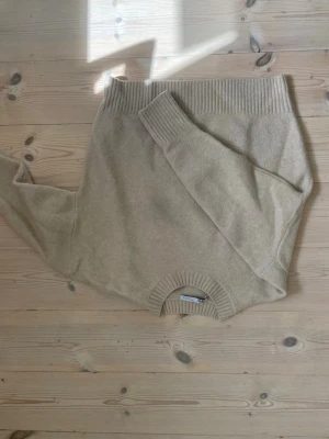 Beige stickad tröja från Zara - Mysig beige stickad tröja från Zara med rund halsringning och ribbade muddar vid hals, ärmslut och nederkant. Perfekt för lager-på-lager och enkel att matcha med olika outfits.