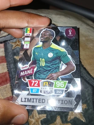 Limited Edition Sadio Mané kort - Säljer ett Limited Edition samlarkort med Sadio Mané från Senegal. Kortet har en glittrig silverbakgrund och visar Mané i grön landslagströja med gula detaljer. Perfekt för dig som samlar på fotbollskort eller gillar VM-tema.