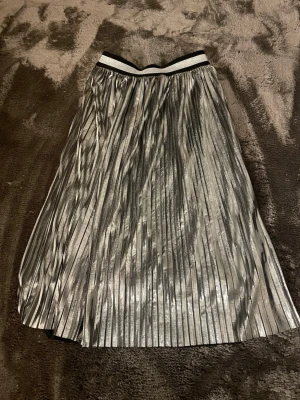 Plisserad silverkjol från KappAhl - Snygg plisserad kjol i metallic silver från KappAhl.