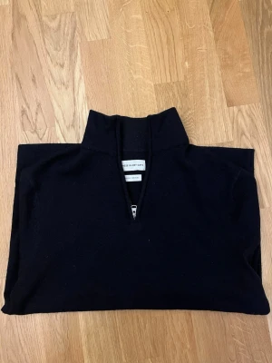 Mörkblå merinoulltröja med halvzip - Stilren mörkblå tröja från These Glory Days i mjuk merinoull. Tröjan har hög krage och halvzip framtill, perfekt för en clean och modern look. Materialet är Superior Merino som känns lyxigt och håller värmen.  Nypris: 1099kr