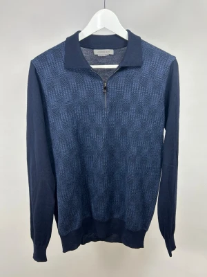 Corneliani Half-Zip Navy  - Snygg mörkblå half-zip tröja från Corneliani i 100% virginull, riktigt skön kvalitet! Storlek S/M, modellen är 175 cm och väger 70 kg. Nypris ca 5000:-. Inga defekter, fint skick. Framsidan har ett diskret mönster medan ärmar och rygg är enfärgade. Tillverkad i mjukt material som sitter skönt på kroppen. Perfekt till jeans eller chinos.