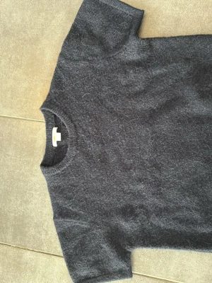 Mörkblå stickad t-shirt - Fin mörkblå stickad T-shirt. Nästan aldrig använd och säljer eftersom den är för liten. 