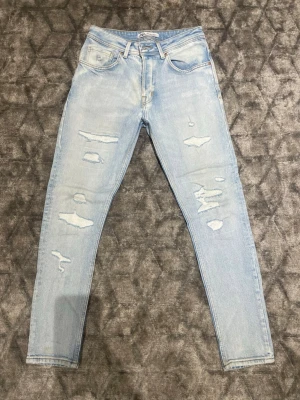 Ljusblå slitna skinny jeans - Säljer ett par ljusblå skinny jeans med slitningar och hål på framsidan. Jeansen har klassisk femficksmodell, normal midja och är tillverkade i denim med stretch. Perfekta för en avslappnad och trendig look. 👀 Skickas inom 24h! 💬 priset kan diskuteras vid snabb köp!