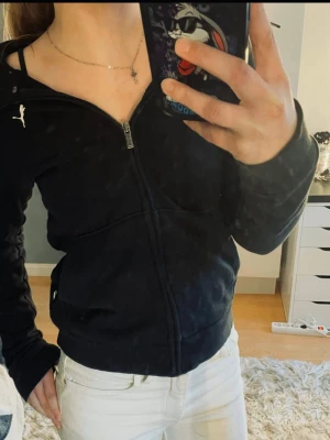 Svart zip hoodie från Puma - Säljer en svart hoodie från Puma med dragkedja framtill och vit Puma-logga på bröstet. Hoodien har huva och stora fickor framtill. Tillverkad i mjukt och bekvämt material (ej tjockt matrial) , perfekt för chill dagar eller träning. Ej bra pris,,, skriv till mig