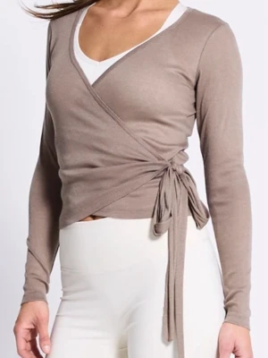 Beige omlottopp med knytband - Trendig beige omlottopp med långa ärmar och knytband i sidan. Toppen har en v-ringad hals och croppad passform som ger en snygg siluett. Aldrig använt . Helt ny