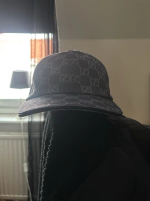 Gucci GG keps – blå/grå monogram – unisex - Säljer en stilren Gucci keps i klassiska GG Supreme-monogrammet i blå/grå ton. Tidlös modell som passar både dam och herr. Perfekt för att lyfta en enkel outfit och ge den en exklusiv touch.  Kepsen är i fint skick och sparsamt använd. Bekväm passform med böjd skärm och justerbar bak för optimal fit.  ✨ Trendig ✨ Lättmatchad färg ✨ Statement-accessoar