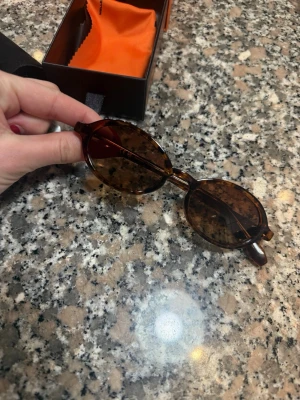 Runda bruna solglasögon från Monokel - Snygga runda solglasögon från Meller med brunmelerade bågar och mörka linser. Kommer med original förpackning och putsduk. Jag har aldrig använt dem. Endast provade. Ord pris 580kr