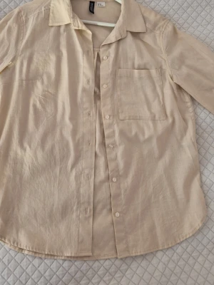 Beige skjorta från H&M  - Beige damskjorta från H&M💘 köpt några år tillbaka men inte använd! Storlek XS, men har en mer oversized passform! Perfekt för en mer avslappnad stil! Passa på, fri frakt en vecka fom 15/2! 