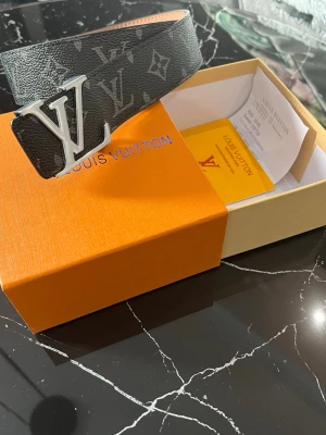 L V BÄLTE - Ett helt nytt bälte med svarta/gråa detaljer. Storlek 110cm. Kontakta mig vid intresse 😁