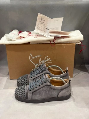 Grå Christian Louboutins  - Grå Christian Louboutins junior spikes | Skick - 9,5/10 | Inga defekter | Storlek - 41 | Box, 2 dustbags, extra snören, extra nitar + kvitto medföljer vid köp | Nypris - 10 000kr+ | ÄKTA | Hör av er vid frågor eller funderingar 🙌