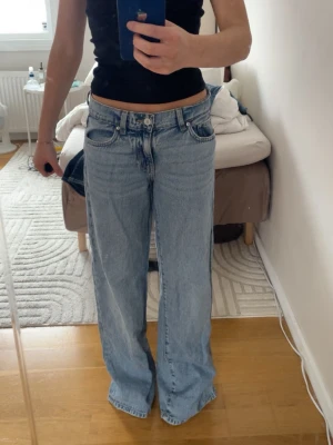 Ljusblåa baggy jeans med låg midja - Säljer ett par ljusblåa baggy jeans med låg midja och raka, vida ben. Klassisk femficksmodell i mjuk denim. Perfekta för en avslappnad och trendig look. Passar dig som gillar loose fit och streetstyle.