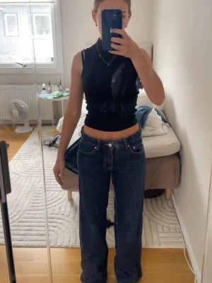 Mörkblå raka jeans med hög midja - Säljer ett par mörkblå jeans med raka ben och hög midja. Jeansen har klassiska fem fickor och kontrastsömmar. Passar perfekt till en avslappnad och trendig stil. Materialet är kraftigt denim i bomull.