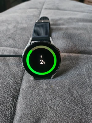 Samsung Galaxy Watch 4 svart - Snygg Samsung Galaxy Watch 4 med rund svart urtavla och svart silikonarmband. Klockan har Gorilla Glass DX+ och aluminiumhölje. Perfekt för dig som vill ha koll på notiser, träning och hälsa direkt på handleden. 7 st armband+ laddare. Det svarta armbandet är original men från en tidigare klocka. Fungerar med både BT och E-sim. Återställd. Lite småmärken efter normal användning. Se bilder.