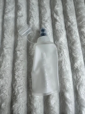 Vattenflaska / löparflaska  - Säljer en helt nya fvatteflaska som passar bra till löpning och i en löparväst, fortfarande plomberad. Rymmer 150ml. Säljer även en löparväst i min profil. 