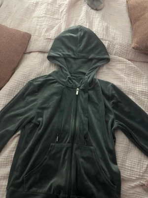 Grå velourhoodie från Gina Tricot - Mjuk och skön grå hoodie i velour från Gina Tricot. Hoodien har dragkedja framtill, stora fickor och justerbar huva med snören. Perfekt för en chill och avslappnad stil.