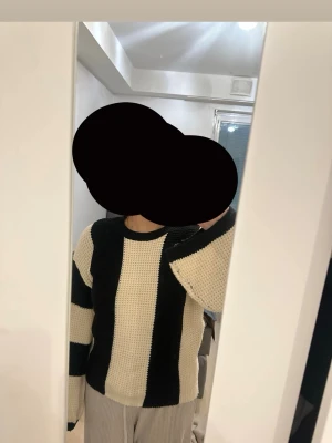 Svartvit randig stickad tröja - Säljer en stickad tröja med breda svarta och vita vertikala ränder. Tröjan har rund halsringning och långa ärmar. Materialet ser ut att vara mjukt och grovstickat, perfekt för en avslappnad och trendig look.