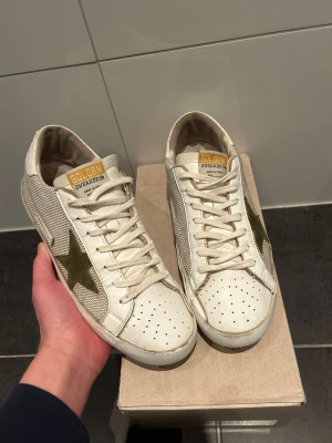 Golden Goose vita sneakers med stjärna - Hej! Säljer ett par riktigt snygga goolden goose skor för endast 750. Skorna är i bra skick och kommer med låda.            Priset är inte huggit i sten!!!                                  Följer du mig på plick får du 50 kr i rabbat!!! 
