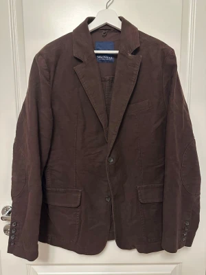 Brun kavaj från McNeal - Brun McNeal kavaj strl 52. 100 % Bomull. Ärmlängd (cm) 68 , Axelbredd (cm) 52. Lite sliten (se sista bild)