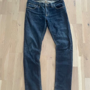Mörkblå jeans från Nudie Jeans - Säljer ett par riktigt schysta nudie jeans i modellen long john. Dem har en klassisk slim fitt passform och är i storlek 31/34. Dem är i toppskick och har inga defekter eller liknande 