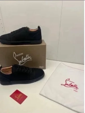 SÖKER!!🥺 Svarta sneakers från Christian Louboutin - Säljer ett par stilrena svarta sneakers från Christian Louboutin. Skorna har en klassisk låg profil med snörning och är tillverkade i mocka för en lyxig känsla. Kommer med originalkartong och dustbag med logga.