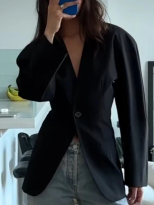 Svart kavaj från Gina Tricot - OBS första bilden är inte min, jag ville bara visa hur kavajen ser ut när den bärs. Stilren svart kavaj från Gina Tricot med djup V-ringning och enkel knappstängning. Kavajen har två fickor framtill och är helfodrad. Perfekt för en clean och modern look. Materialet ser ut att vara en mix av polyester och viskos. Storlek L. O