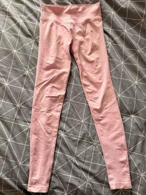 Rosa seamless leggings från Forcy - Säljer ett par ljusrosa seamless leggings från Forcy! De har hög midja och är tillverkade i ett stretchigt, mjukt material som sitter skönt mot kroppen. Perfekta för träning eller chill dagar. Klassisk passform utan synliga sömmar på benen. Aldrig använt, nypris 499kr.