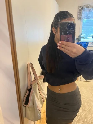 Mörkgrå tight kjol - Säljer en mörkgrå tight kjol i kort modell. Kjolen har en enkel och stilren design utan mönster eller detaljer, vilket gör den lätt att matcha med olika toppar. Perfekt för dig som gillar en basic och clean look.