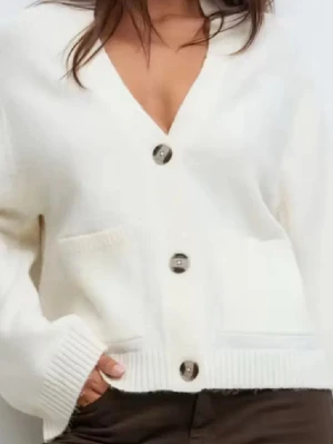 Vit kofta med stora knappar - Säljer min vita stickade kofta med knappar från Ginatricot i storlek M. Helt ny, prislapp kvar. Slutsåld. en krämvit, kofta med djup V-ringning och stora, silvriga knappar. Koftan har två framfickor och breda ribbade muddar vid ärmslut och nederkant. Perfekt för lager på lager och riktigt mysig att bära.