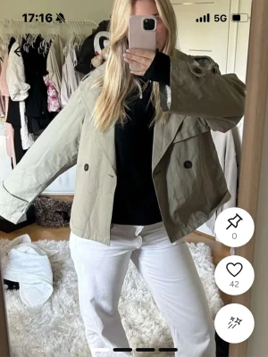 Kort beige trenchcoat med dubbelknäppning - Snygg grön trenchcoat! Knappt använd och perfekt nu inför våren. Skriv för fler bilder🙏🏼🤗🥰