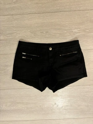 Svarta shorts - Lågmidjade svarta shorts med dragkedjor framtill.
