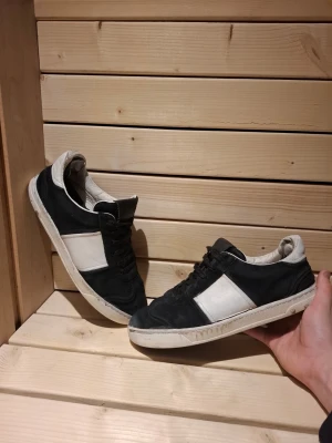 Svart vita Valentino Flycrews med mockadetaljer - Snygga Valentino Flycrews i svart och vitt.  Skorna är i mocka med vita paneler på sidorna och svarta snören. Skorna har en liten defekt i fram vilket ses lite otydligt på bilderna bara att fråga om ni vill ha fler bilder på det 🙂, de saknas även några spikar på båda skorna skriv om ni vill ha mer bilder på de eller om ni vill diskutera priset. De är i storlek 39 men de funkar för mig som har 42 om jag tar ur sulan så de är väldigt stora i storlek med sula skulle jag säga att de är runt 40-41 