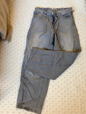 Jeans - Jeans med lös fit. Knytband i midjan. Använda men i mycket fint skick. Mellanhög midja. Strl 28/32