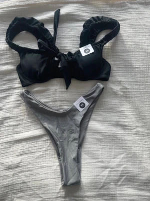 Svart och grå bikini i XS - ny!! - Superfin bikini från Bik Bok - storlek XS - ny med prislapp.  Svart bikinitopp och grå bikinitrosa.
