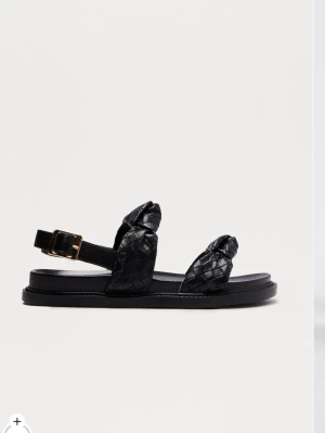 Svarta  sandaler med spänne - Snygga svarta sandaler med flätade remmar och justerbart guldfärgat spänne. Jätte bekväma!! Aldrig använda!!