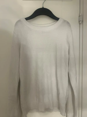 Vit stickad tröja från VILA - Klassisk vit stickad tröja från VILA med rund halsringning och ribbade muddar vid ärmslut och nederkant. Tröjan har en enkel och stilren design som passar till det mesta. Perfekt basplagg för lager på lager och enkel att matcha.
