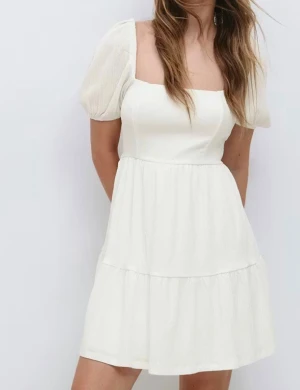 Vit kort klänning  - Supersöt vit kort klänning med puffärm. Klänningen är sällan använd och det går att få fler bilder vid intresse. 